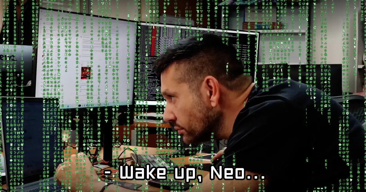 Marios Tsopouridis at his workstation with Matrix-style code raining over the screen and the caption Wake up, Neo